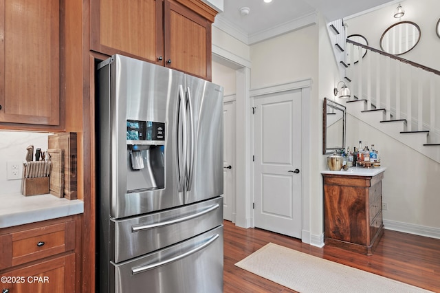 kitchen featuring ornamental molding, stainless steel refrigerator with ice dispenser, and dark wood-type flooring