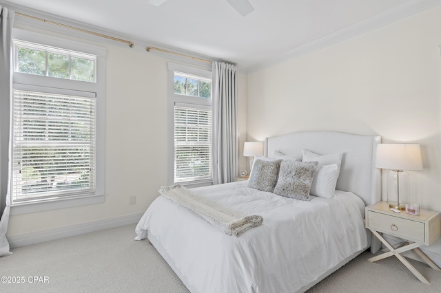 carpeted bedroom with ceiling fan and ornamental molding