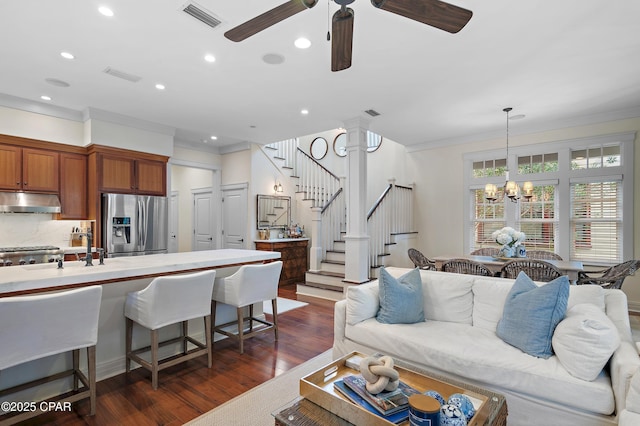 living room with ceiling fan with notable chandelier, dark hardwood / wood-style floors, ornamental molding, and sink