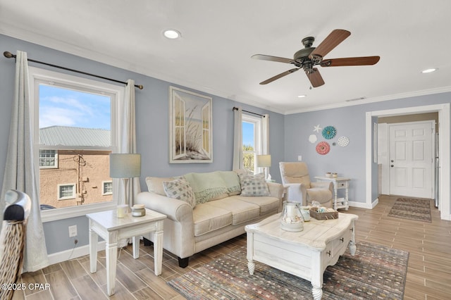 living room with wood finish floors, ceiling fan, ornamental molding, and baseboards