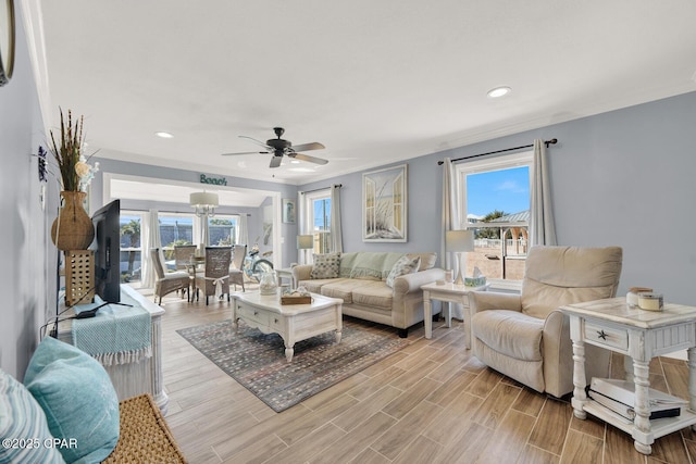 living area featuring recessed lighting, ceiling fan with notable chandelier, and light wood-type flooring