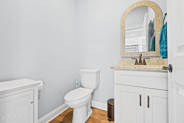 bathroom with hardwood / wood-style floors, vanity, and toilet