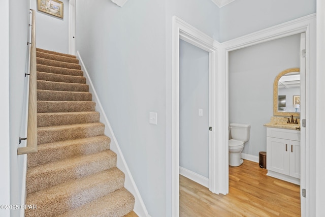 stairway with hardwood / wood-style flooring and sink