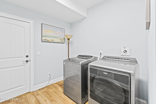 laundry area featuring washer and dryer and light hardwood / wood-style floors