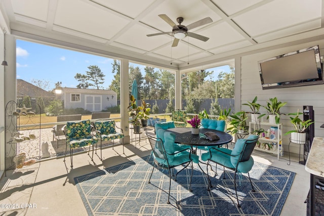 sunroom / solarium featuring ceiling fan, plenty of natural light, and coffered ceiling