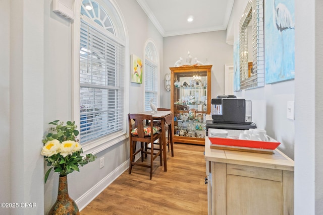 office with light wood-type flooring and ornamental molding