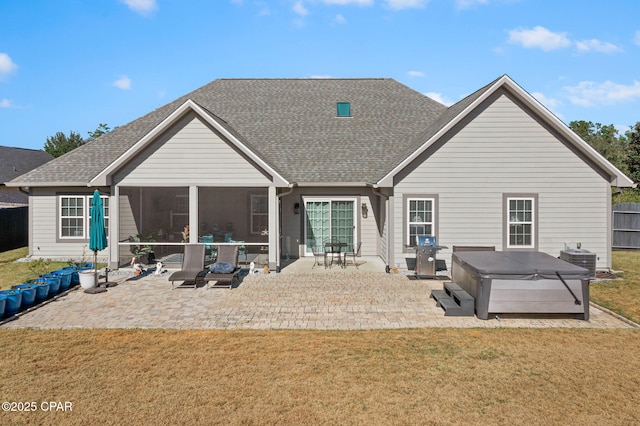 back of property with a patio, a hot tub, a lawn, and central air condition unit