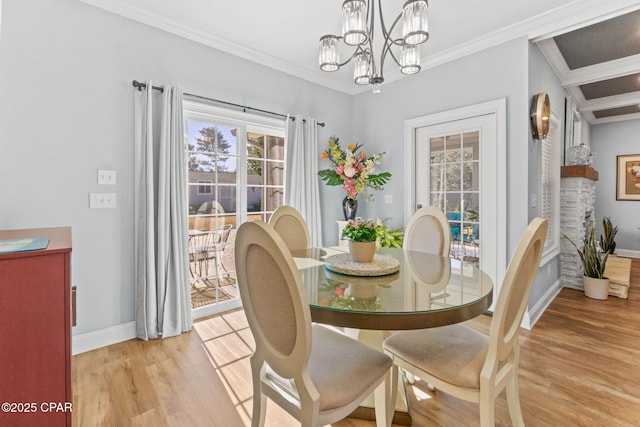 dining area featuring light wood-type flooring, crown molding, and a chandelier