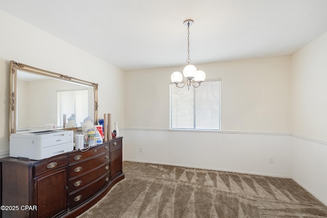 carpeted empty room featuring an inviting chandelier