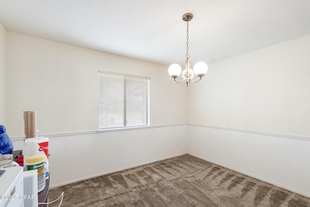 carpeted empty room with a chandelier