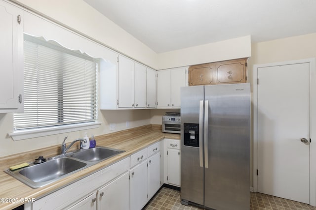 kitchen with white cabinets, sink, and stainless steel refrigerator with ice dispenser