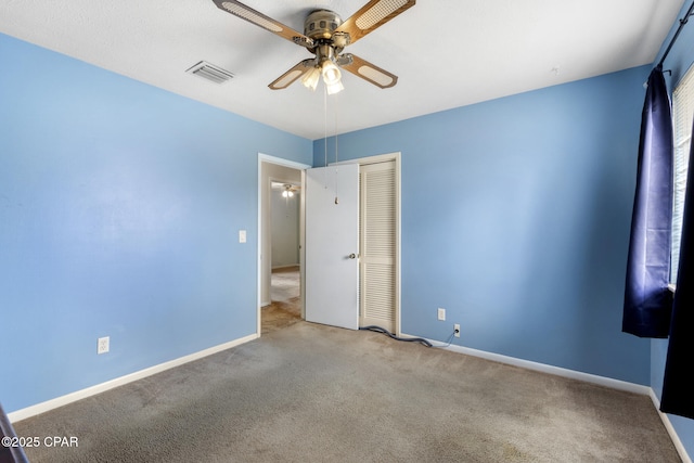 unfurnished bedroom with ceiling fan, light carpet, and a closet