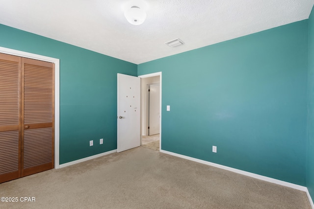 unfurnished bedroom with light carpet and a closet