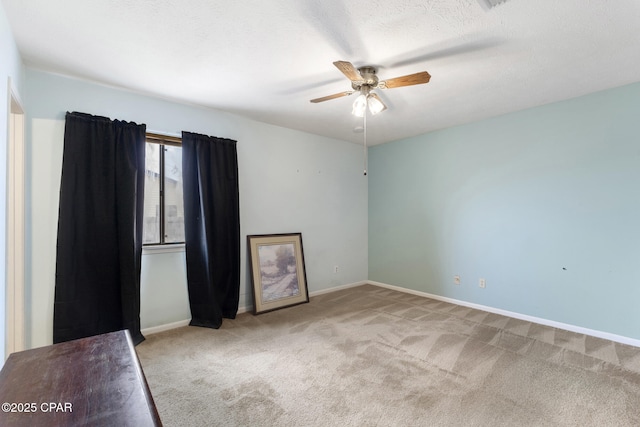 carpeted spare room featuring ceiling fan and a textured ceiling