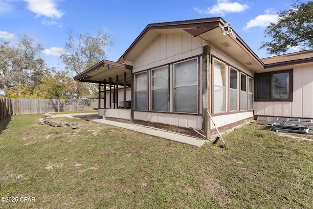 view of side of property with a sunroom and a lawn