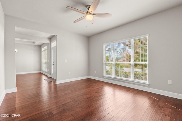 empty room with dark wood-type flooring and ceiling fan