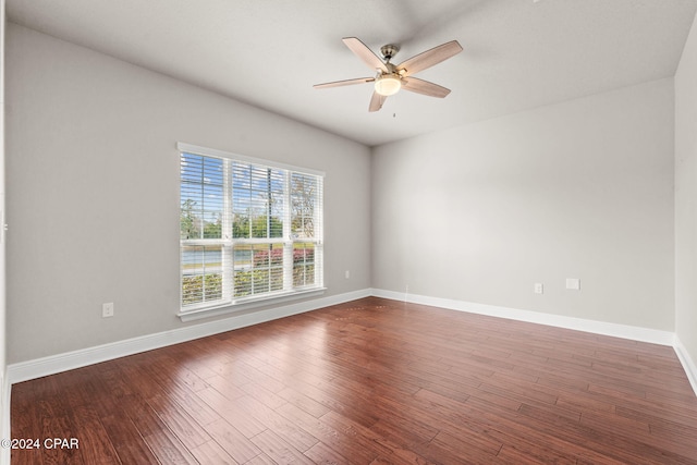 empty room with ceiling fan and dark hardwood / wood-style flooring