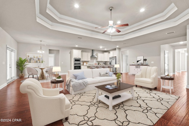 living room featuring crown molding, hardwood / wood-style flooring, and a tray ceiling