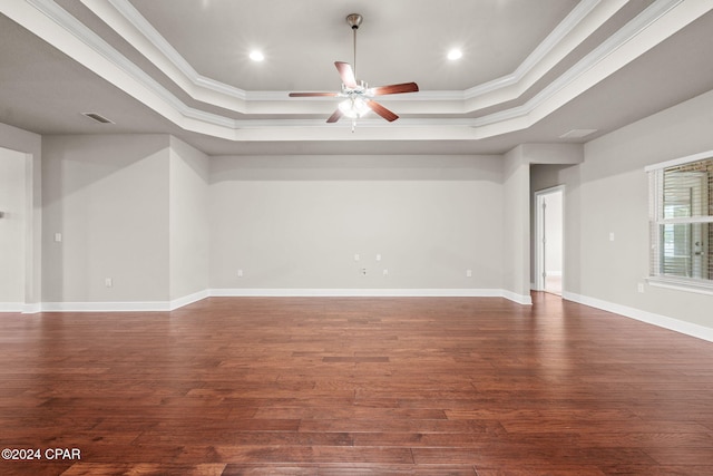 unfurnished room featuring dark hardwood / wood-style flooring, a raised ceiling, and ornamental molding