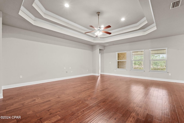 spare room with ceiling fan, crown molding, hardwood / wood-style floors, and a raised ceiling