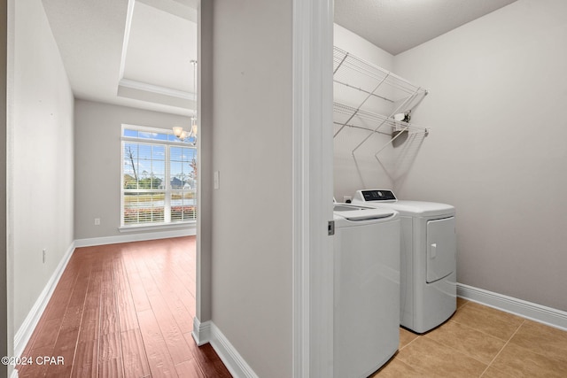 laundry area with an inviting chandelier and separate washer and dryer