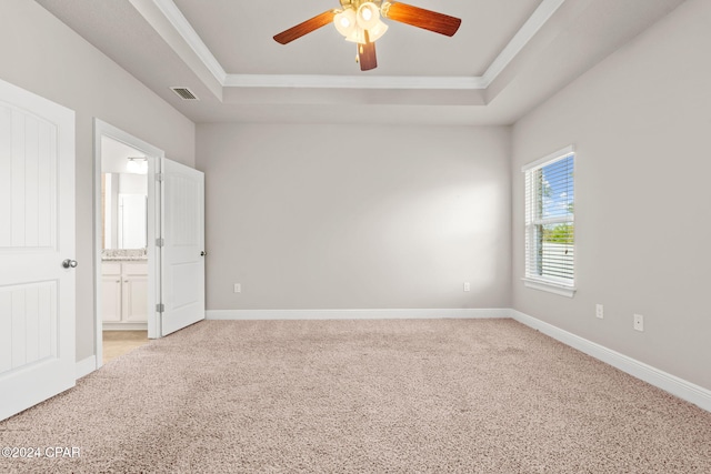 unfurnished room featuring ceiling fan, crown molding, light carpet, and a tray ceiling