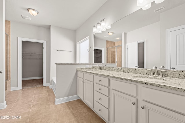 bathroom with an enclosed shower, vanity, and tile patterned floors