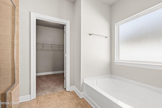 bathroom with independent shower and bath and tile patterned floors