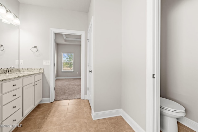 bathroom featuring toilet, tile patterned flooring, and vanity