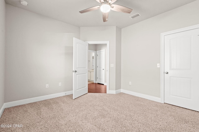 unfurnished bedroom featuring ceiling fan and dark carpet