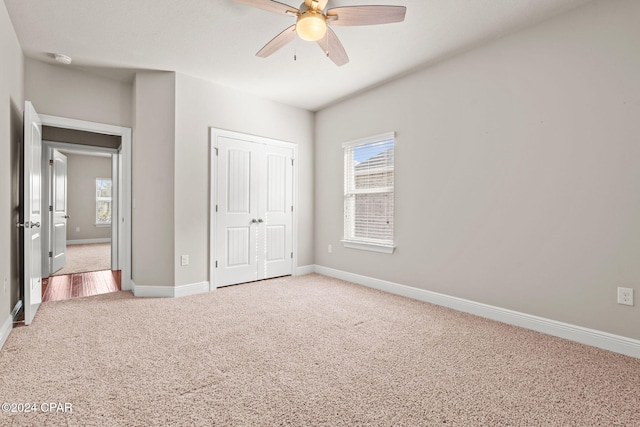 unfurnished bedroom with a closet, ceiling fan, and light carpet