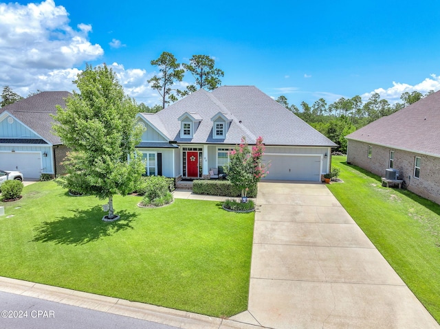 view of front of house featuring cooling unit, a front lawn, and a garage