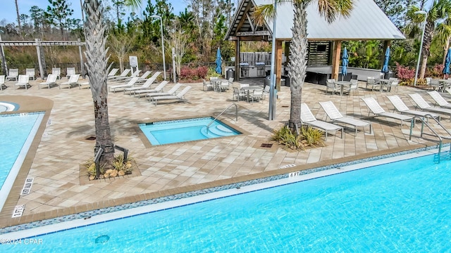 view of pool featuring a gazebo, a patio, and a hot tub