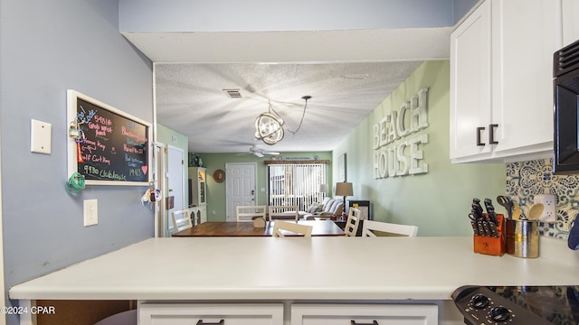 kitchen with visible vents, white cabinets, and light countertops