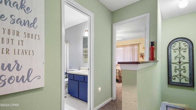 hallway with a textured ceiling and baseboards