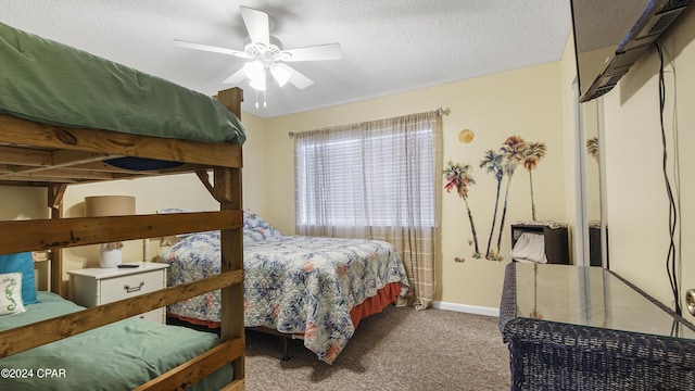 carpeted bedroom with a ceiling fan, a textured ceiling, and baseboards