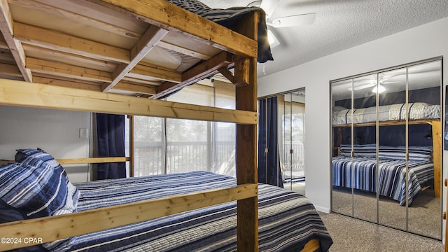 bedroom with multiple closets, carpet, a textured ceiling, and a ceiling fan