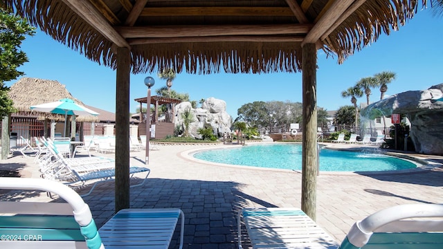 community pool with a patio area and fence