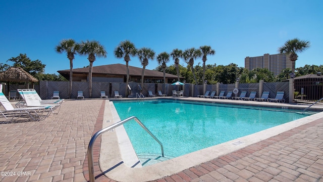 community pool featuring fence and a patio