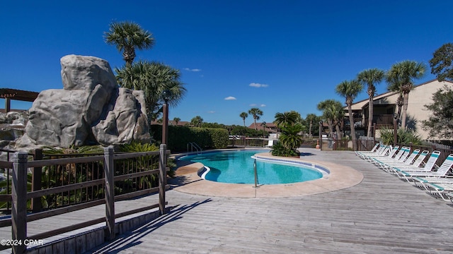 pool with fence and a wooden deck