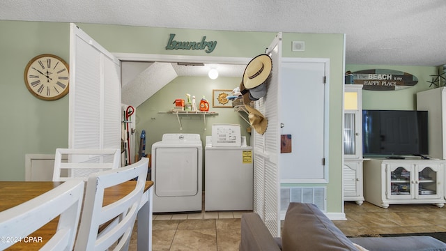 clothes washing area with laundry area, visible vents, tile patterned floors, independent washer and dryer, and a textured ceiling