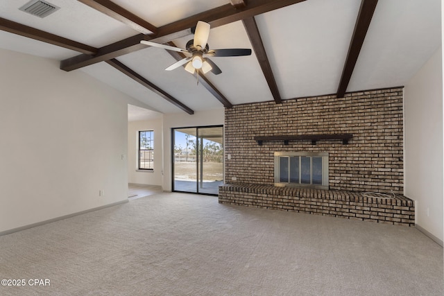 unfurnished living room with lofted ceiling with beams, light colored carpet, a brick fireplace, and ceiling fan