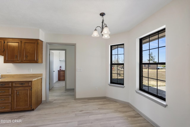 unfurnished dining area featuring light hardwood / wood-style flooring and a chandelier