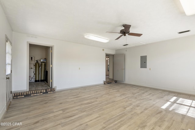 spare room with light wood-type flooring, electric panel, and ceiling fan