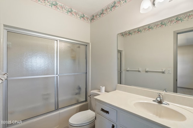 full bathroom featuring vanity, toilet, and bath / shower combo with glass door