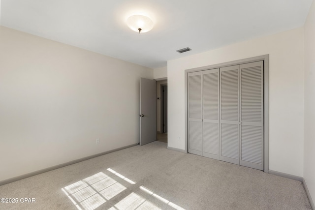 unfurnished bedroom featuring a closet and light colored carpet