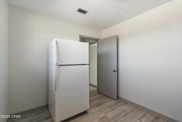 kitchen with white refrigerator and light hardwood / wood-style flooring