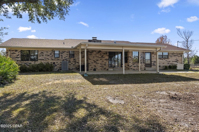 back of house featuring a lawn, a patio area, and central AC