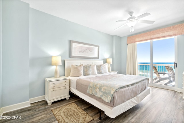 bedroom featuring access to exterior, dark hardwood / wood-style flooring, a water view, and ceiling fan