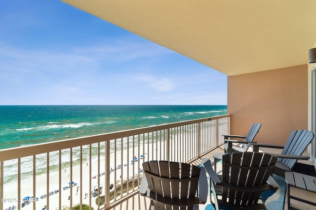 balcony featuring a view of the beach and a water view